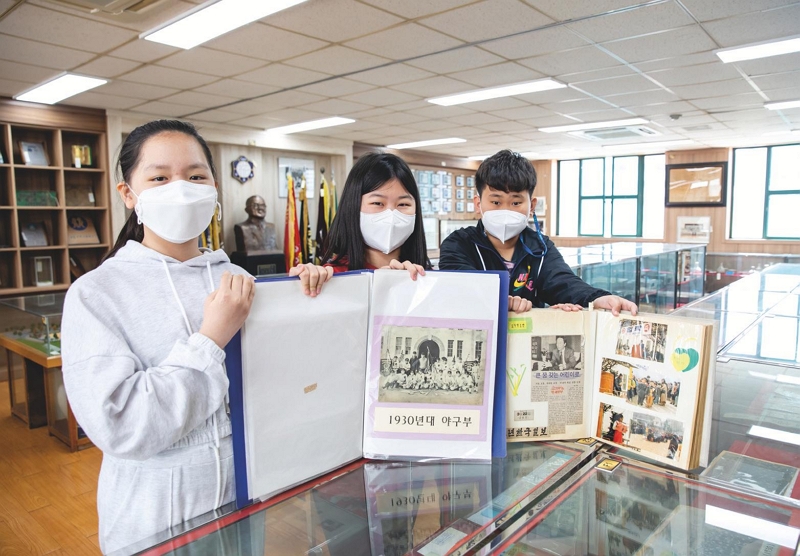  올해 역사관 도우미로 활동하게 된 6학년  이가영·최수아·박건휘 학생(왼쪽부터). 관심  있는 사료를 골라 담당 교사와 함께 공부하고,  시나리오를 직접 작성해 연습한다.