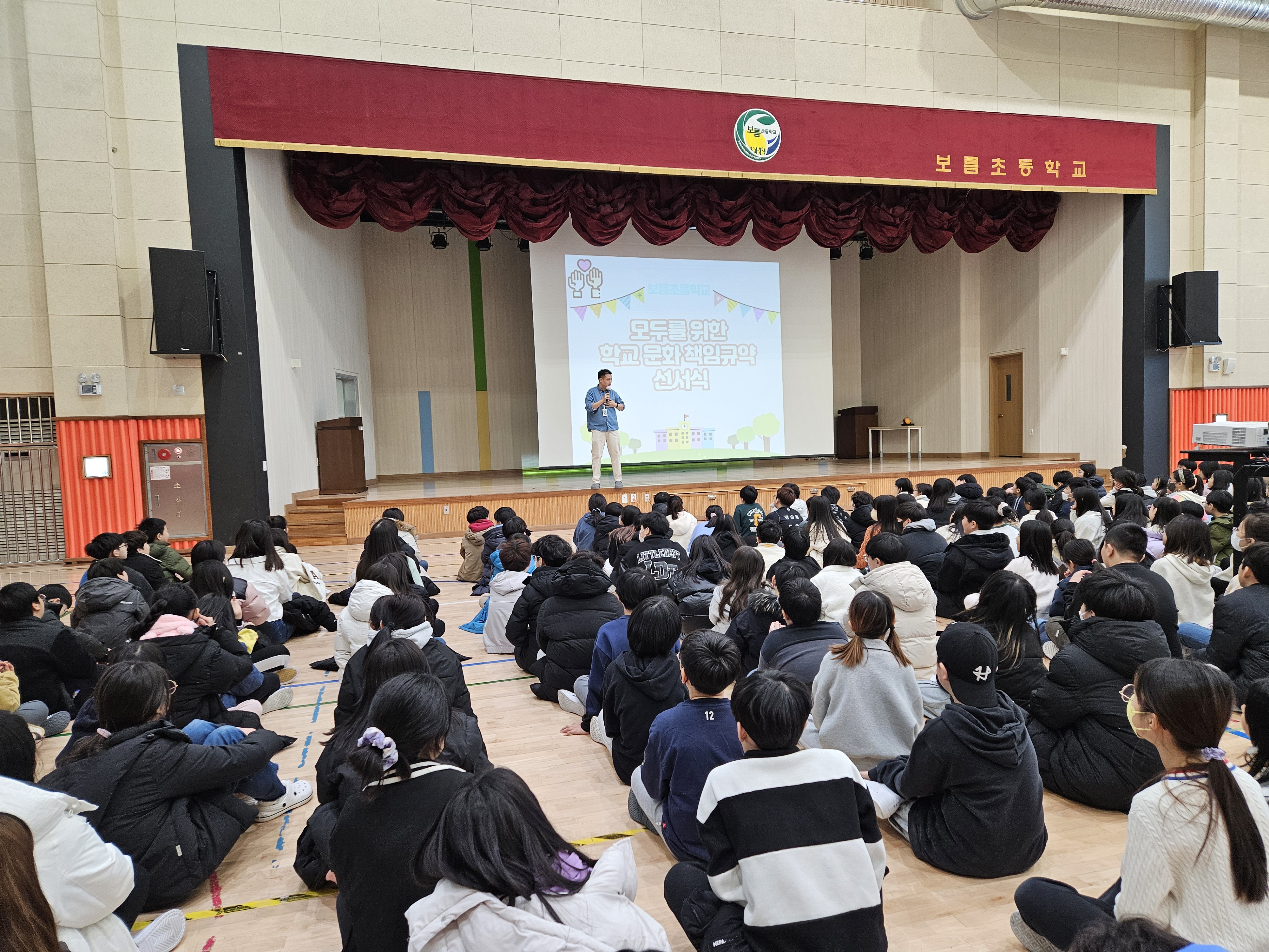 김포 보름초등학교의 학생들이 인성교육의 일환으로 이루어지는 모두의 학교 책임규약에 대해 설명을 듣고 있다.