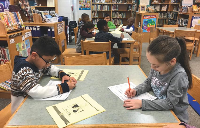 2학년 학생들이 학교도서관에서 사서교사의 지도에 따라 조별로 연구활동을  하고 있다.