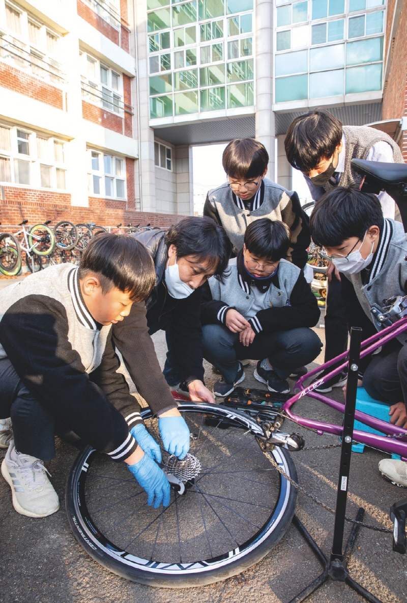 이종윤 교사로부터 자전거디스크브레이크에 대한 설명을 듣고 있는 페달링 부원들